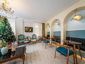 ein Zimmer mit Weihnachtsbaum, Tischen und Stühlen in der Unterkunft Triana Hotel in Antalya