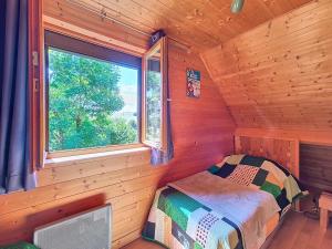a bedroom with a bed and a window in a log cabin at Chalet L'Adret in Besse-et-Saint-Anastaise