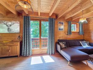 a living room with a couch and a large window at Chalet L'Adret in Besse-et-Saint-Anastaise