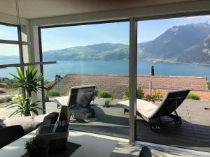 a view of a lake from a house with windows at Apartment Gemütliche Apartment by Interhome in Krattigen