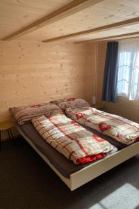 a bed in a room with a wooden wall at Apartment Alpenruh by Interhome in Gadmen +15 photos