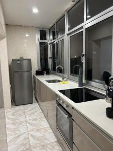 a kitchen with a sink and a refrigerator at Apartamento próximo da praia e do centro da cidade in Póvoa de Varzim