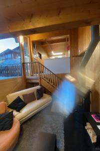 a living room with a couch and a staircase at Apartment Hockenhorn by Interhome in Wiler