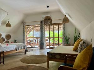 a bedroom with a bed and a large window at Boutique Villa Unaweza in Matemwe +79 photos