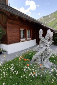 a statue in front of a house with flowers at Apartment Steinideen by Interhome in Meiringen