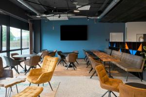 a room with tables and chairs and a flat screen tv at Four Points Flex by Sheraton Östringen in Östringen