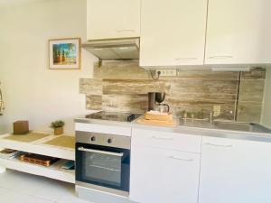 a kitchen with white cabinets and a sink at Excellence Suites Orient Beach Oceanview King-Size Beach Pool Parking in Cul de Sac