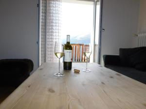 a bottle of wine and two glasses on a wooden table at Apartment Alter Konsum by Interhome in Bellwald