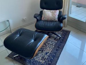 a leather chair and a ottoman in a room at Apartment Apartment 360 by Interhome in Lucerne