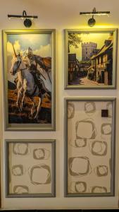 three framed paintings of a horse on a wall at Republika Central Hotel & Resort in Abbottabad +71 photos