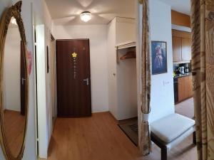 a living room with a mirror and a door at Apartment Royal 22 nahe Klinik- Burgerbad- Einkaufszentrum by Interhome in Leukerbad +10 photos