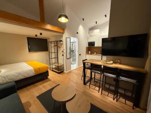 a bedroom with a bed and a table and a television at Cozy Cribs Rasnov in Râşnov