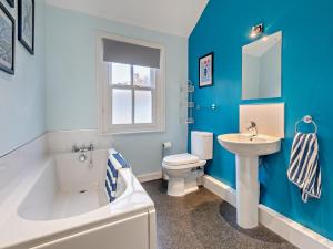 a blue bathroom with a tub sink and a toilet at 2 Bed in Keswick oc-sz006 in Keswick +9 photos