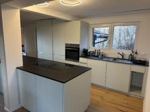 a kitchen with white cabinets and a black counter top at Apartment Sunnehöckli by Interhome in Hasliberg