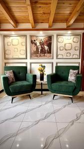 a living room with two green chairs and a table at Republika Central Hotel & Resort in Abbottabad