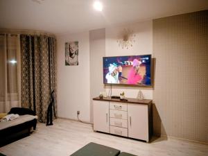 a living room with a flat screen tv on the wall at APaRTAMENT MOUTAIN SKY in Świeradów-Zdrój +4 photos