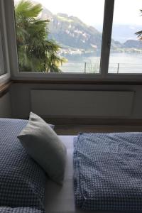 a bedroom with a bed and a large window at Apartment Weggis by Interhome in Weggis +9 photos