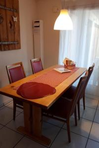 a wooden table with chairs and a red plate on it at Apartment Baldo by Interhome in Sörenberg