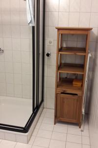 a bathroom with a shower and a wooden shelf at Apartment Baldo by Interhome in Sörenberg