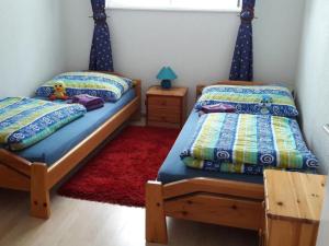 a bedroom with two twin beds and a red rug at Apartment Baldo by Interhome in Sörenberg