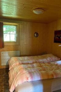 two beds in a wooden room with a window at Holiday Home Chalet Glücksfall by Interhome in Bellwald