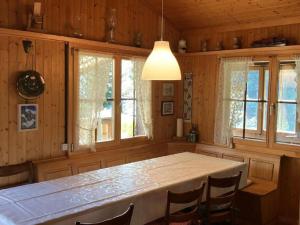 a dining room with a table and some windows at Holiday Home Chalet Glücksfall by Interhome in Bellwald