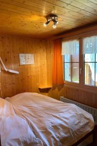 a bedroom with a bed in a wooden room at Holiday Home Chalet Glücksfall by Interhome in Bellwald +5 photos