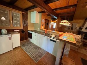 a kitchen with white appliances and a wooden ceiling at Holiday Home Chalet Glücksfall by Interhome in Bellwald