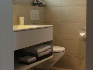 a bathroom with a sink and a toilet with towels at Apartment Lauigrund by Interhome in Sörenberg