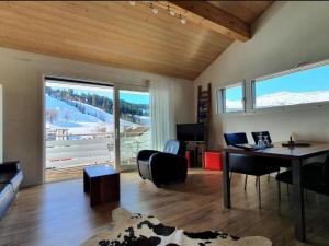 a living room with a desk and a table with chairs at Apartment Lauigrund by Interhome in Sörenberg
