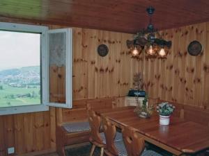 a dining room with a wooden table and a window at Apartment Fruehalp by Interhome in Unterägeri