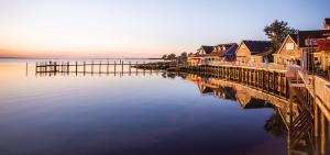 a bridge over a body of water next to houses at This Home Has It All Location Amenities & More in Duck