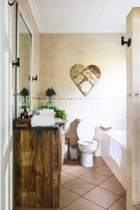 a bathroom with a toilet and a heart on the wall at Shekinah Cabin in Hartbeespoort