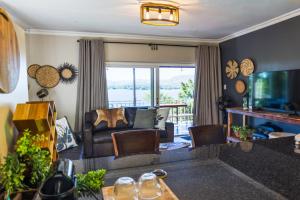 a living room with a couch and a television at Shekinah Cabin in Hartbeespoort