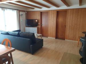 a living room with a couch and a tv at Apartment Saturn by Interhome in Sörenberg +8 photos