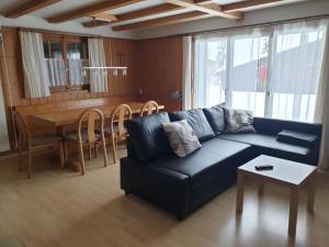 a living room with a blue couch and a table at Apartment Saturn by Interhome in Sörenberg