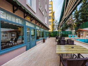 eine Terrasse mit Tischen und Stühlen an einem Gebäude in der Unterkunft Triana Hotel in Antalya