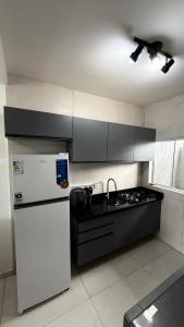 a kitchen with a white refrigerator and a sink at Duplex completo, perto da praia e no centro de Imbé in Imbé +7 photos