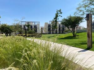 a path in a park with tall grass and a building at LUMINARIA Pool, Near the Historic Center | Elegant in San Miguel de Allende