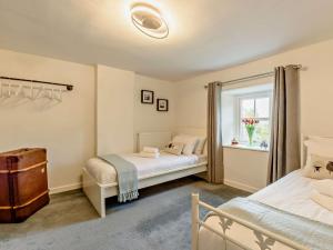 a bedroom with two beds and a window at 3 Bed in Egremont oc-90050 in Hale