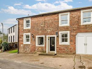 a brick house with white windows and a garage at 3 Bed in Egremont oc-90050 in Hale