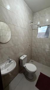 a bathroom with a toilet and a sink at Duplex completo, perto da praia e no centro de Imbé in Imbé
