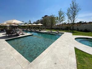 a large swimming pool with chairs and umbrellas at LUMINARIA Pool, Near the Historic Center | Elegant in San Miguel de Allende
