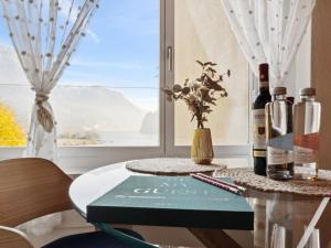 a table with bottles of wine and a book at Apartment Lake View Studio by Interhome in Ingenbohl