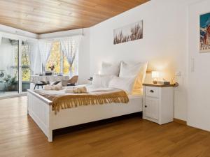 a white bedroom with a bed and a piano at Apartment Lake View Studio by Interhome in Ingenbohl