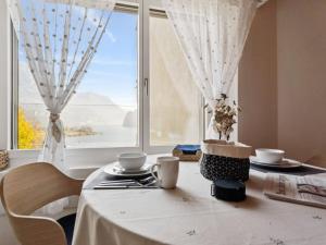 a table with a white table cloth and a window at Apartment Lake View Studio by Interhome in Ingenbohl +11 photos