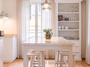 a kitchen with a white table and stools at Holiday Home Verena's B&B by Interhome in Sachseln +45 photos