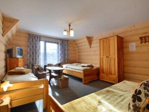 a hotel room with two beds and a television at U Sarapatki-Noclegi z wyżywieniem in Jurgów