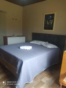 a bedroom with a large bed with a blue blanket at Hostel Hotel uma otima opçao para suas ferias e um bom descanso in Cianorte