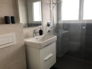 a white bathroom with a sink and a shower at Apartment Studio Rubi Weggis by Interhome in Weggis